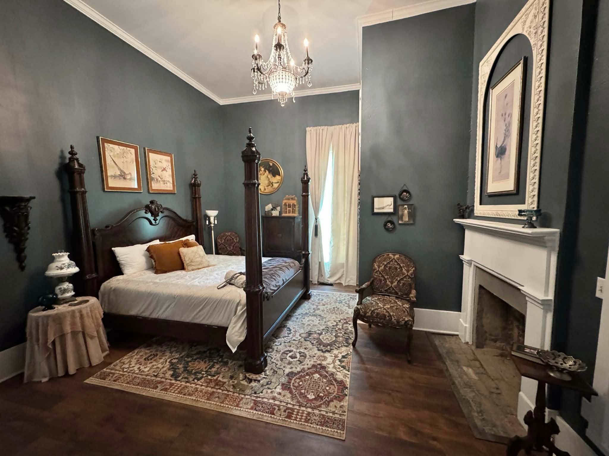 The Peacock Room with dark teal walls and a four-poster bed