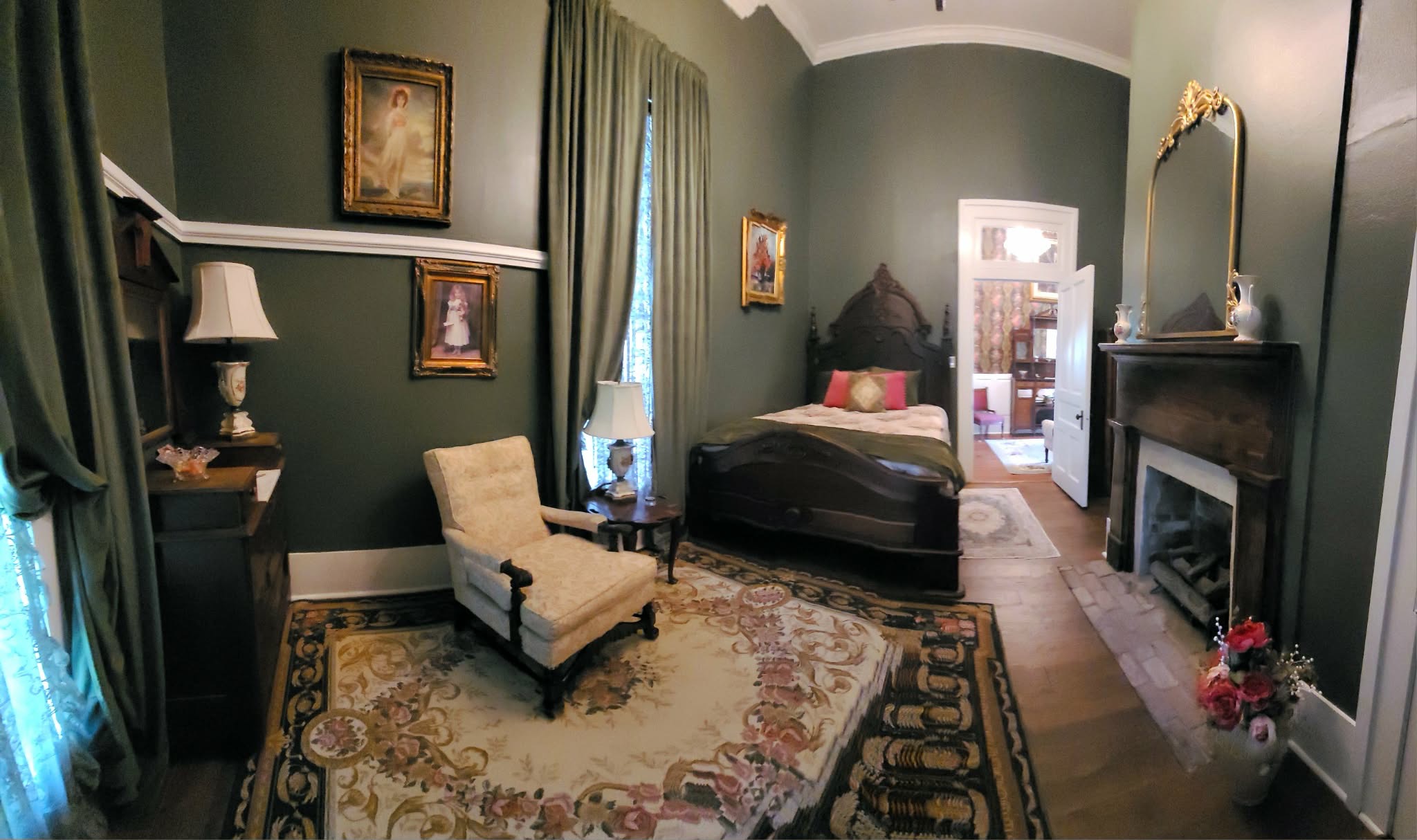 The Olive Room with green walls, fireplace, and antique bed