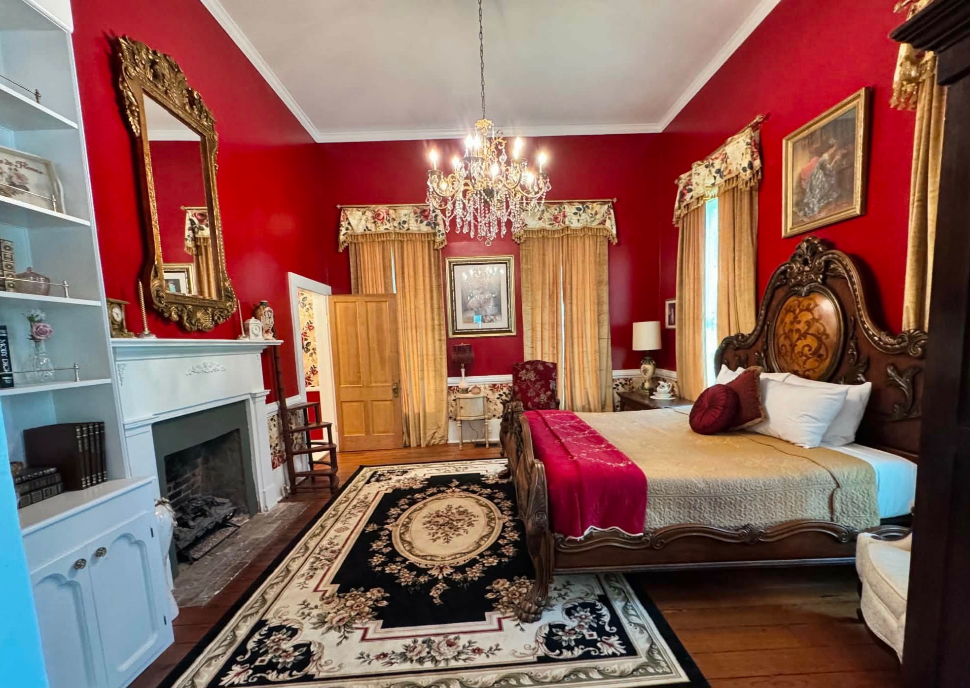 The Rose Room with red walls, crystal chandelier, and ornate furnishings